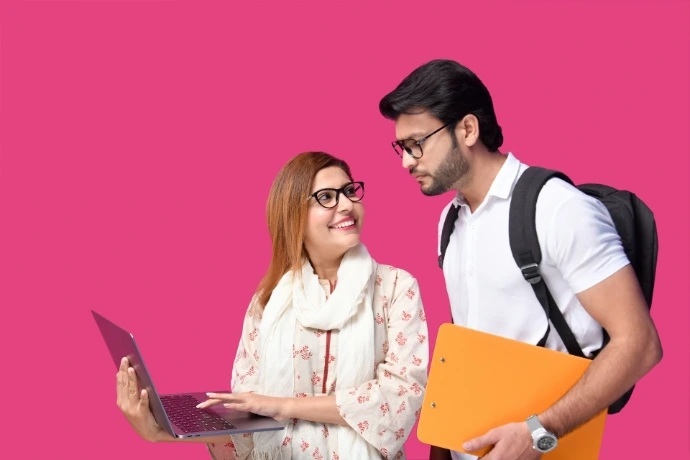 a man and woman looking at a laptop